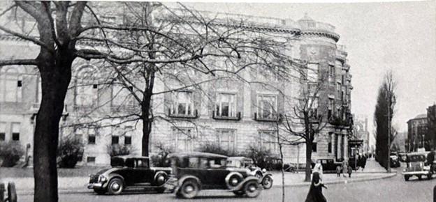 A black and white photo of the Massachusetts Historical Society building in 1932. Pedestrians and old cars pass by in the foreground.